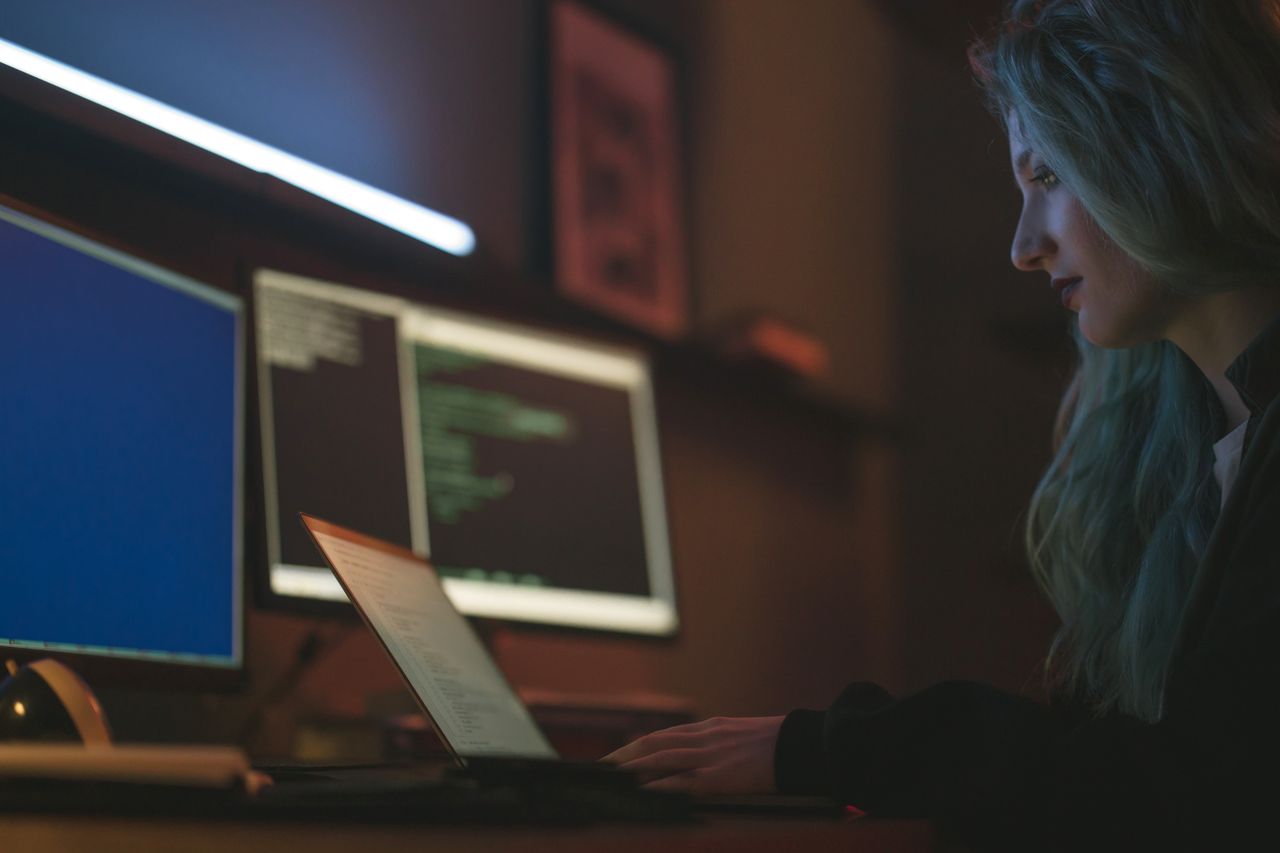 The Art of Drawing Readers In: Your attractive post title goes here Woman working on cybersecurity programming with laptops and multiple screens